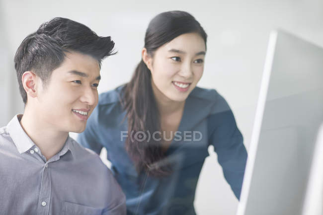 Китайськими колегами за допомогою комп'ютера в офісі — стокове фото