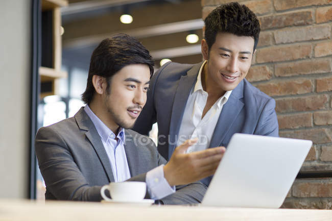 Les hommes asiatiques en utilisant un ordinateur portable dans le café — Photo de stock