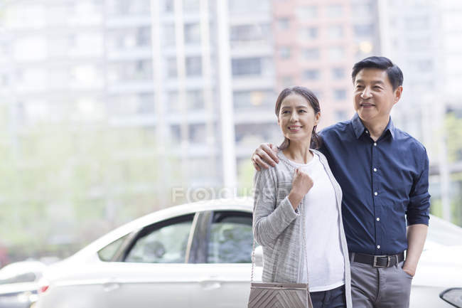 Mature couple chinois debout devant la voiture — Photo de stock