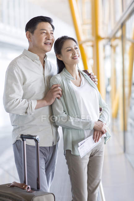 Maturo coppia cinese in piedi in aeroporto con i biglietti — Foto stock
