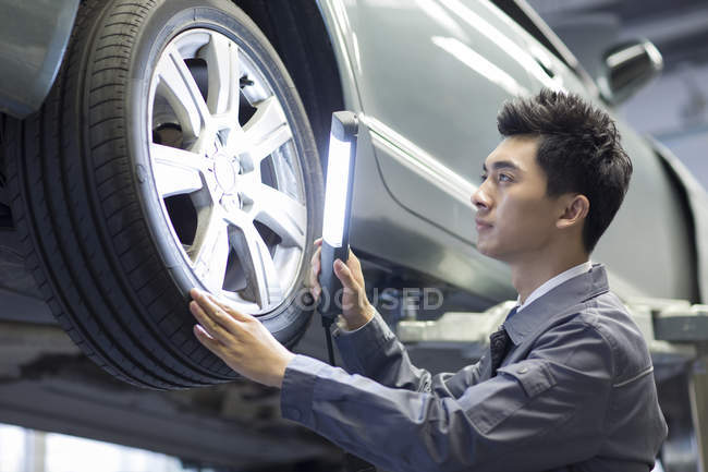 Китайський авто механік вивчення автомобіль з ліхтариком — стокове фото
