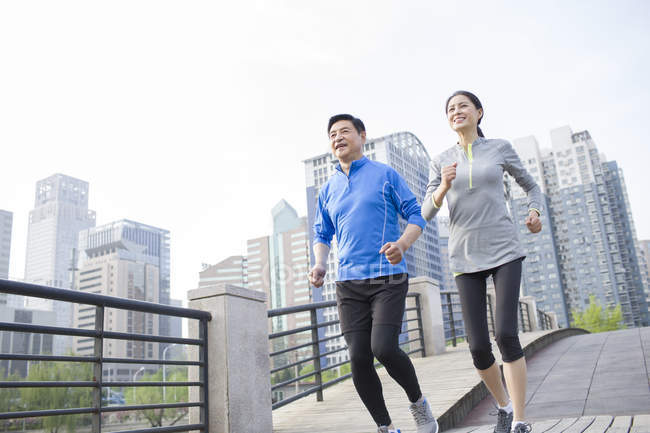 Chinese mature couple running in city — Stock Photo