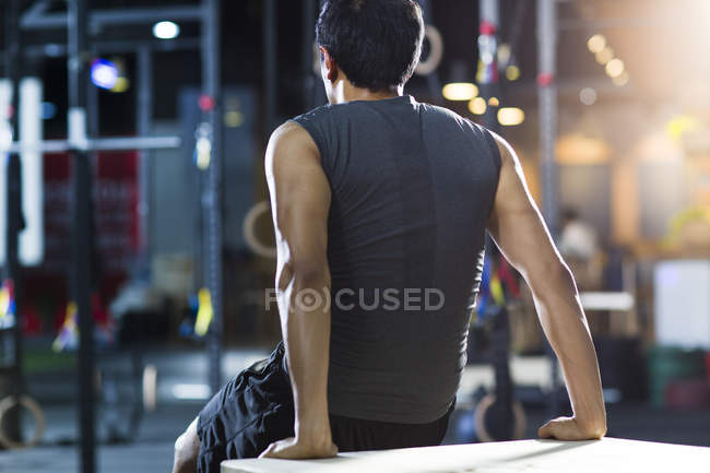 Visão traseira do homem sentado no ginásio — Fotografia de Stock