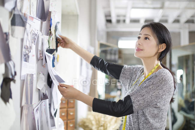 Chinesischer Modeschöpfer arbeitet im Atelier mit Skizzen — Stockfoto