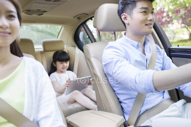 Familia china montando en coche juntos - foto de stock