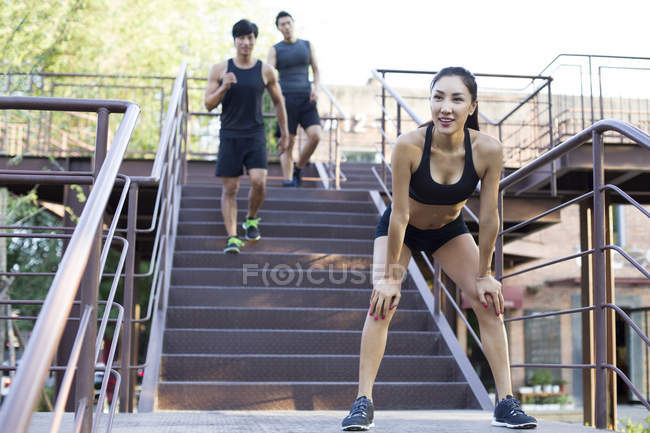 Chinese woman resting after running at stairs — Stock Photo
