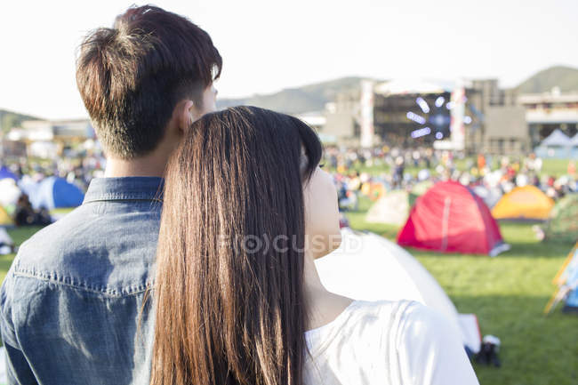 Woman putting head on male shoulder at music festival — Stock Photo