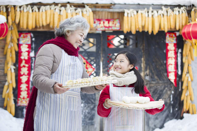 Бабушка и внучка держат китайские пельмени — стоковое фото