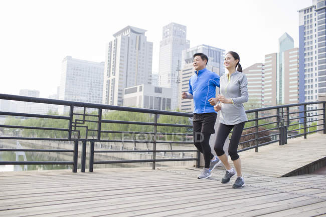 Chinois mature couple courir sur la ville pont — Photo de stock