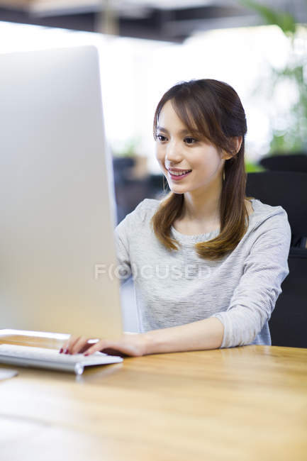 Donna cinese che lavora con il computer in ufficio — Foto stock