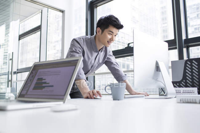 Chinese businessman using computer in office — Stock Photo