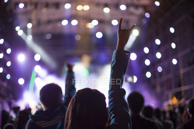 Женщина делает рок-н-ролл знак на концерте — стоковое фото
