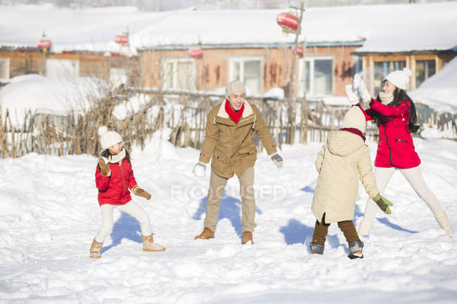 Chinesische Familie mit Kindern bei Schneeballschlacht im Dorf — Stockfoto