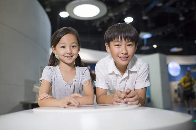Chinesische Kinder sitzen im Museum am Tisch — Stockfoto