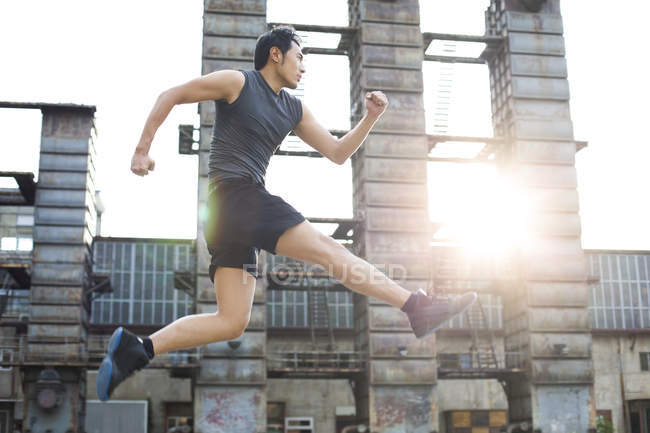 Chinese athlete running and jumping on street — Stock Photo