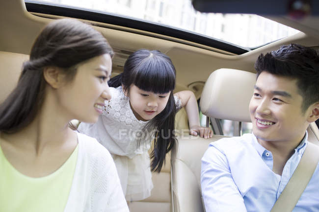 Chinese family with daughter sitting in car — Stock Photo