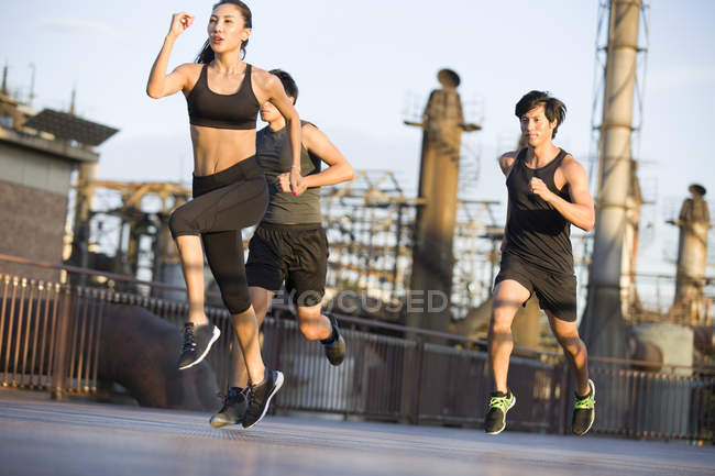 Chinese athletes running at street on bridge — Stock Photo