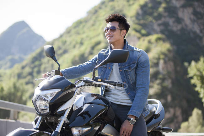 Chinês sentado na motocicleta na estrada — Fotografia de Stock