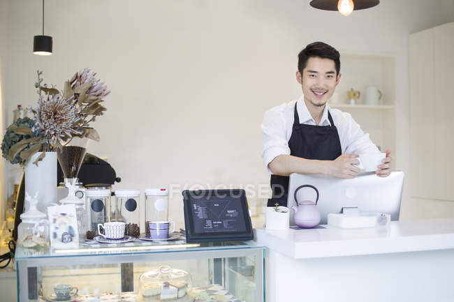 Chinese coffee shop owner at counter — Stock Photo