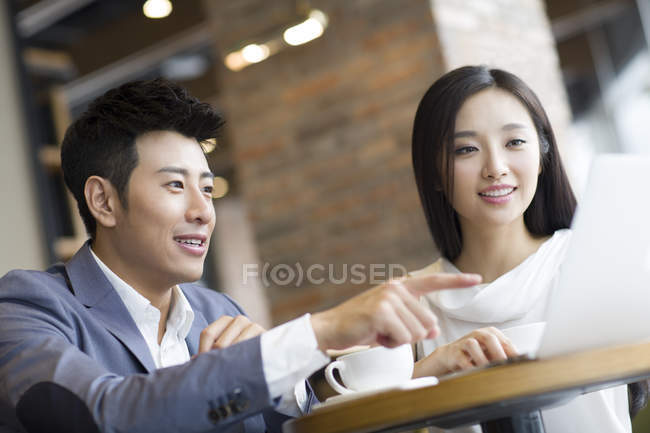 Chinese business people working with laptop in cafe — Stock Photo