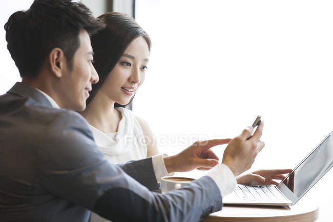 Uomini d'affari cinesi che lavorano con smartphone e laptop — Foto stock