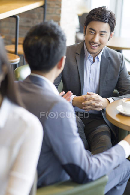 Chinese businessmen on meeting in coffee shop — Stock Photo