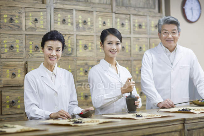 Médicos chineses posando na farmácia tradicional — Fotografia de Stock