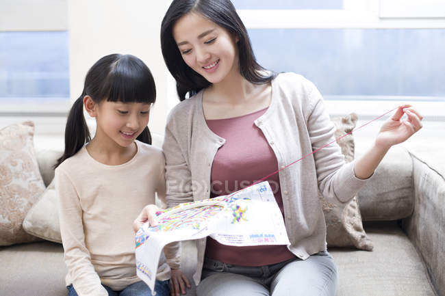 Chinese mother teaching daughter embroidery — Stock Photo