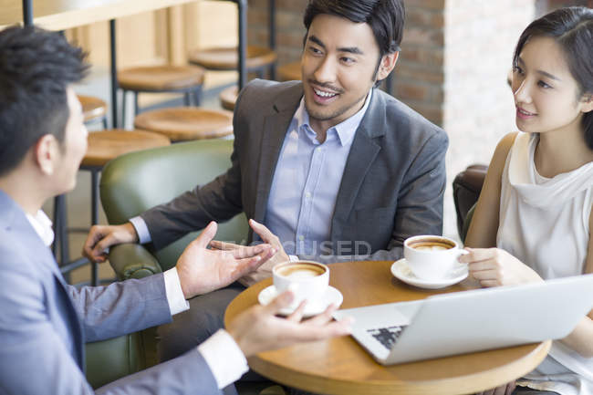 Des hommes d'affaires chinois en réunion dans un café — Photo de stock