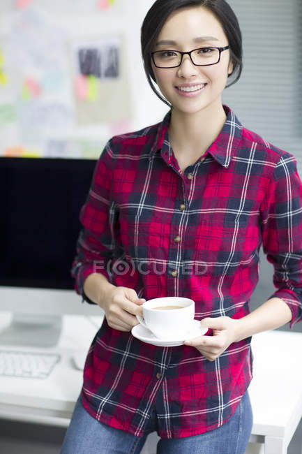 Chinesin hält Tasse Kaffee im Büro — Stockfoto
