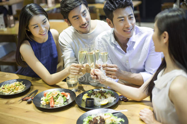 Amis chinois cliquetis verres au dîner — Photo de stock