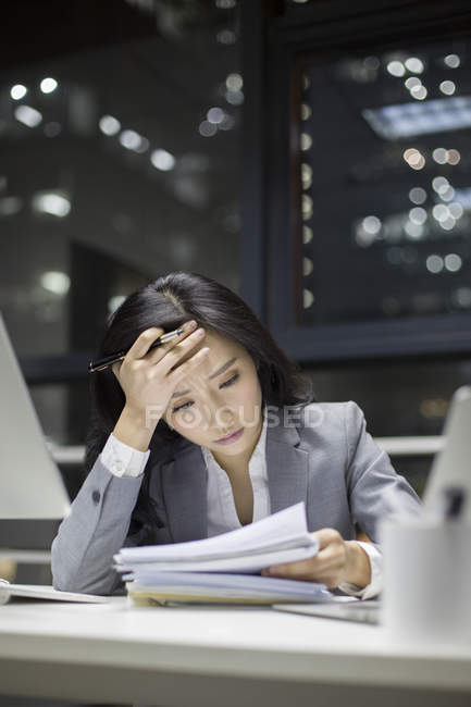 Femme d'affaires chinoise travaillant tard dans le bureau — Photo de stock