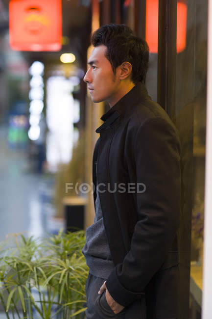 Замислений Китайська чоловік стояв на вулиці і дивитися вбік — стокове фото