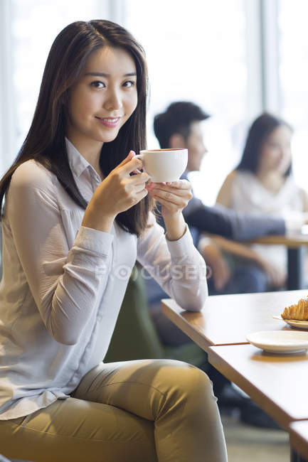 Chinesin sitzt mit Kaffee im Café — Stockfoto