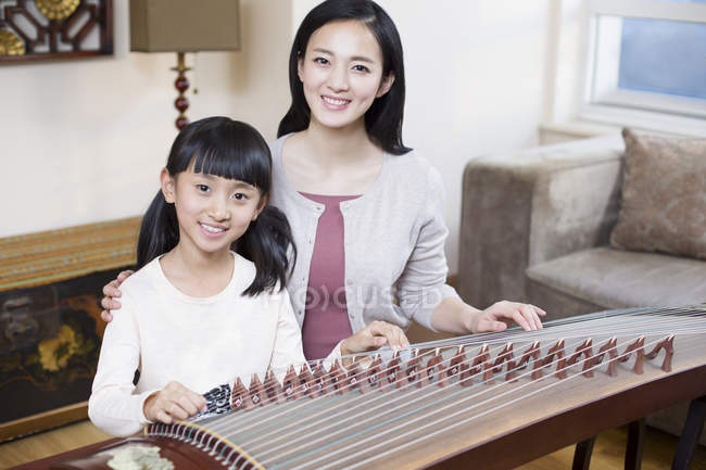 Chinês mãe e filha sentado com tradicional instrumento musical zither — Fotografia de Stock
