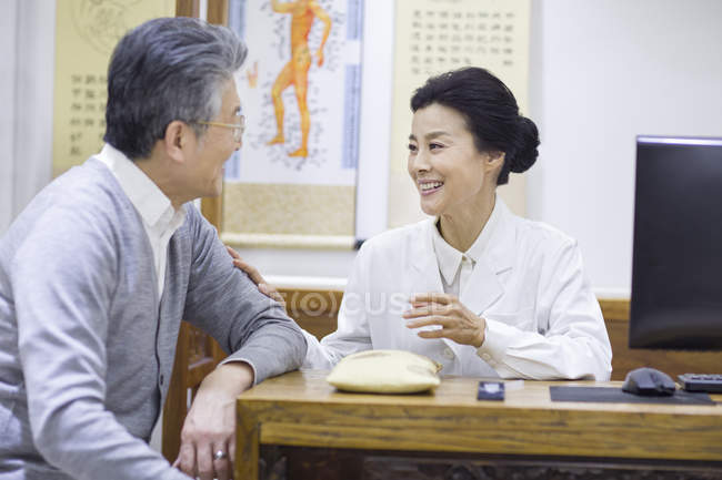 Female Chinese doctor talking with senior patient — Stock Photo
