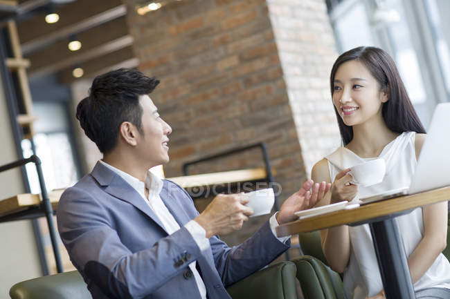 Chinese businesswoman and businessman drinking coffee — Stock Photo