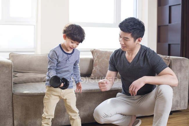 Chinesischer Vater und Sohn üben zu Hause mit Hantel — Stockfoto