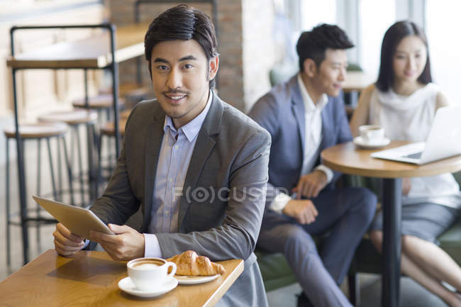 Chinesischer Geschäftsmann benutzt digitales Tablet im Café — Stockfoto