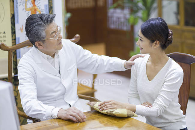 Médico chinês sênior falando com paciente do sexo feminino — Fotografia de Stock