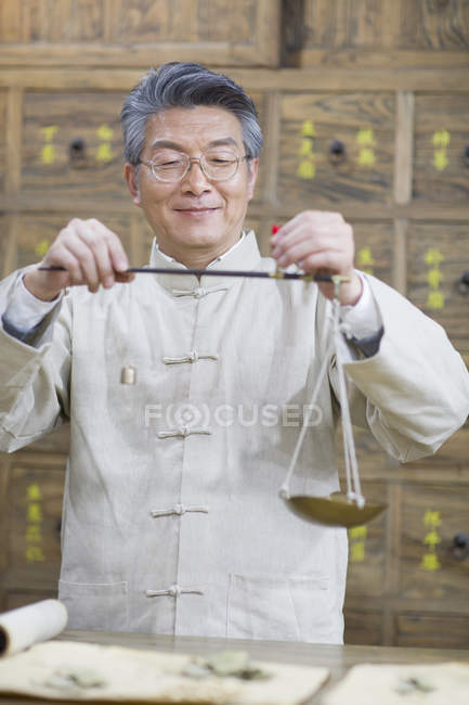 Farmacêutico chinês trabalhando com balança de peso na farmácia — Fotografia de Stock