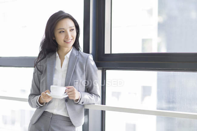 Chinesische Geschäftsfrau macht Kaffeepause bei der Arbeit — Stockfoto