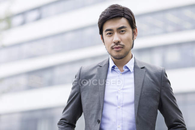 Китайський бізнесмен, стоячи на вулиці і, дивлячись в камери — стокове фото
