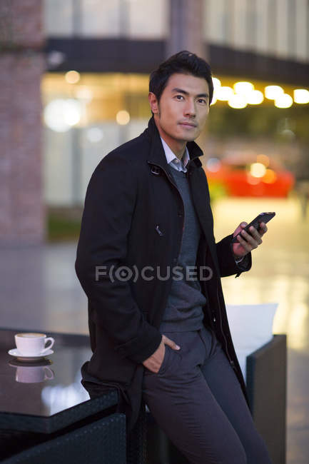 Uomo cinese utilizzando smartphone in città caffè — Foto stock