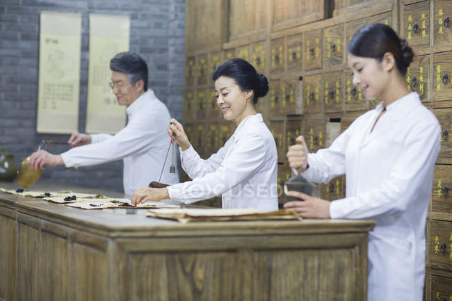 Médicos chineses trabalhando na farmácia tradicional — Fotografia de Stock