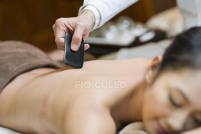 Paciente do sexo feminino recebendo massagem de raspagem na clínica — Fotografia de Stock