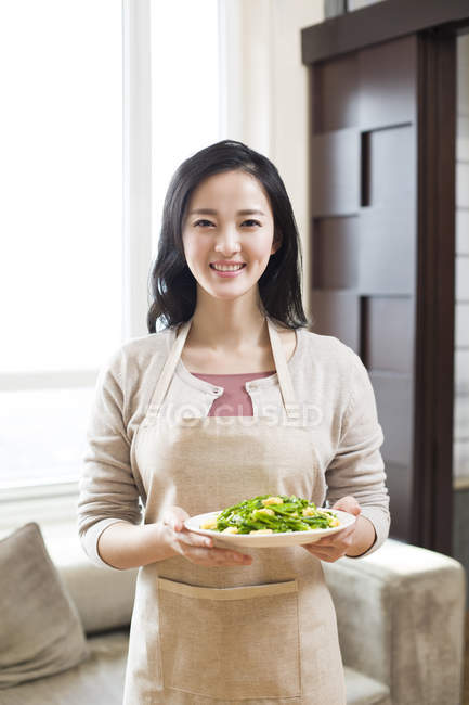 Chinese woman serving plate of food — Stock Photo