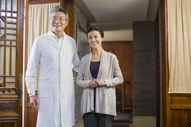 Старший китайський лікаря і зрілі жінки пацієнта в коридорі — стокове фото