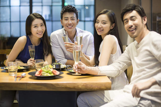 Chinese friends sitting in restaurant together — Stock Photo