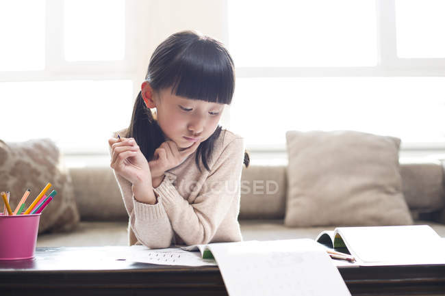 Китайська дівчина, робити домашнє завдання в домашніх умовах — стокове фото